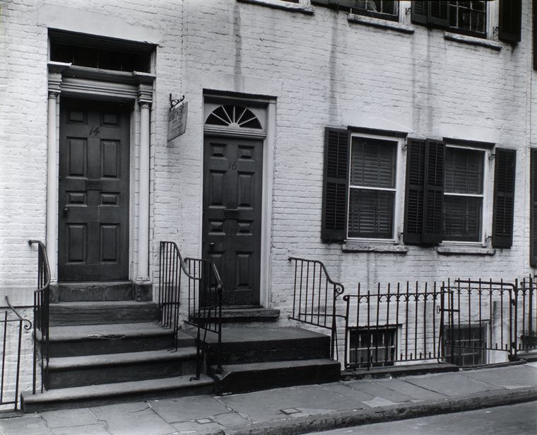 A+black+and+white+photograph+of+the+fa%C3%A7ade+of+14+and+16+Gay+Street.+In+front+of+the+town+houses+is+a+sidewalk.+Railed+staircases+lead+up+to+the+door+steps.+Adjunct+to+the+doors+are+two+windows.