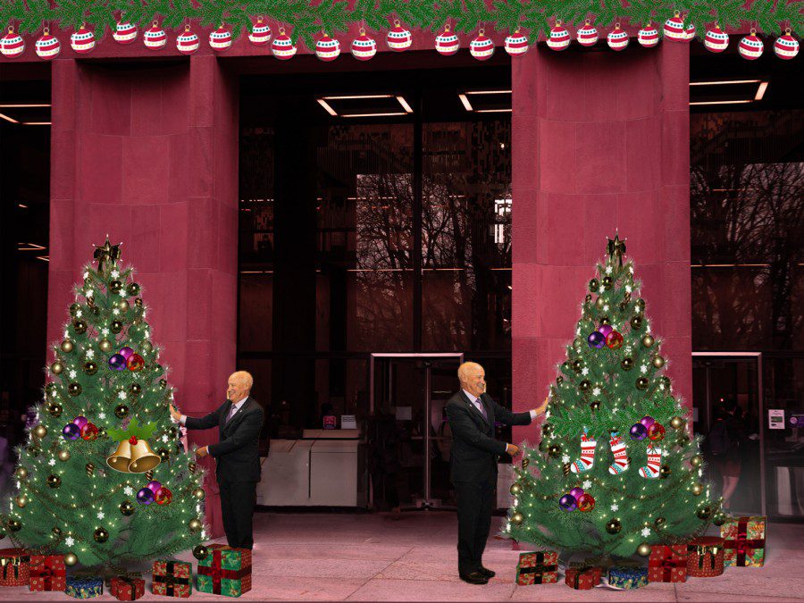 The+red+facade+and+sidewalk+entrance+of+Bobst+Library+is+decorated+with+ornaments+and+garland.+N.Y.U.+president+Andrew+Hamilton+puts+ornaments+on+two+Christmas%2C+which+are+side+by+side.