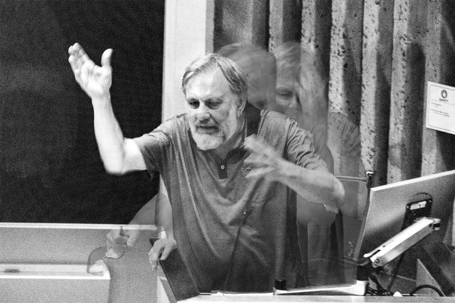 A black-and-white composite of several photos layered over one another depicting the philosopher Slavoj Zizek gesticulating wildly while speaking at a podium.
