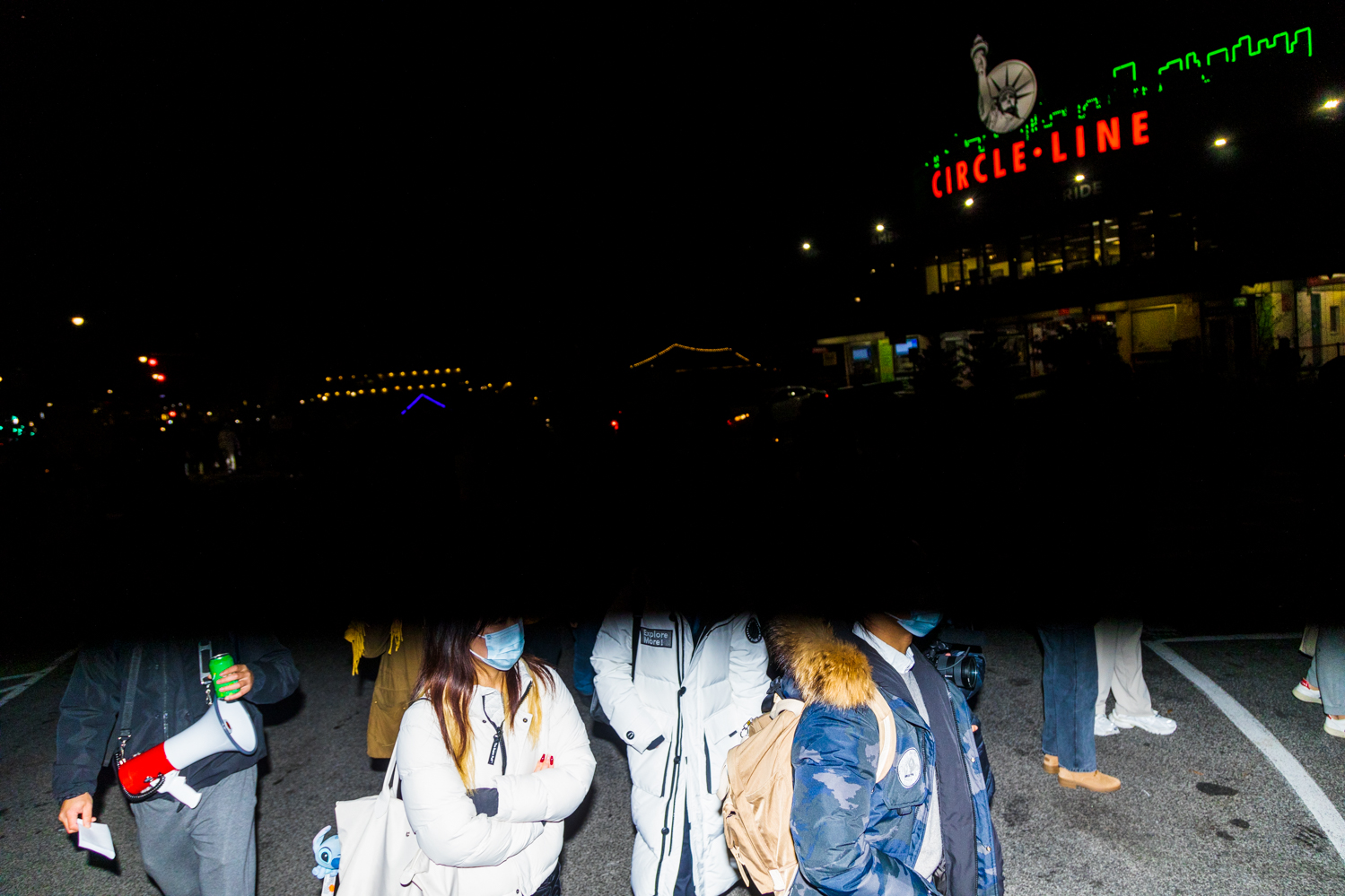 A half-exposed image showing the lower torsos of protesters proceeding to Pier 84 at Hudson River Park at night.