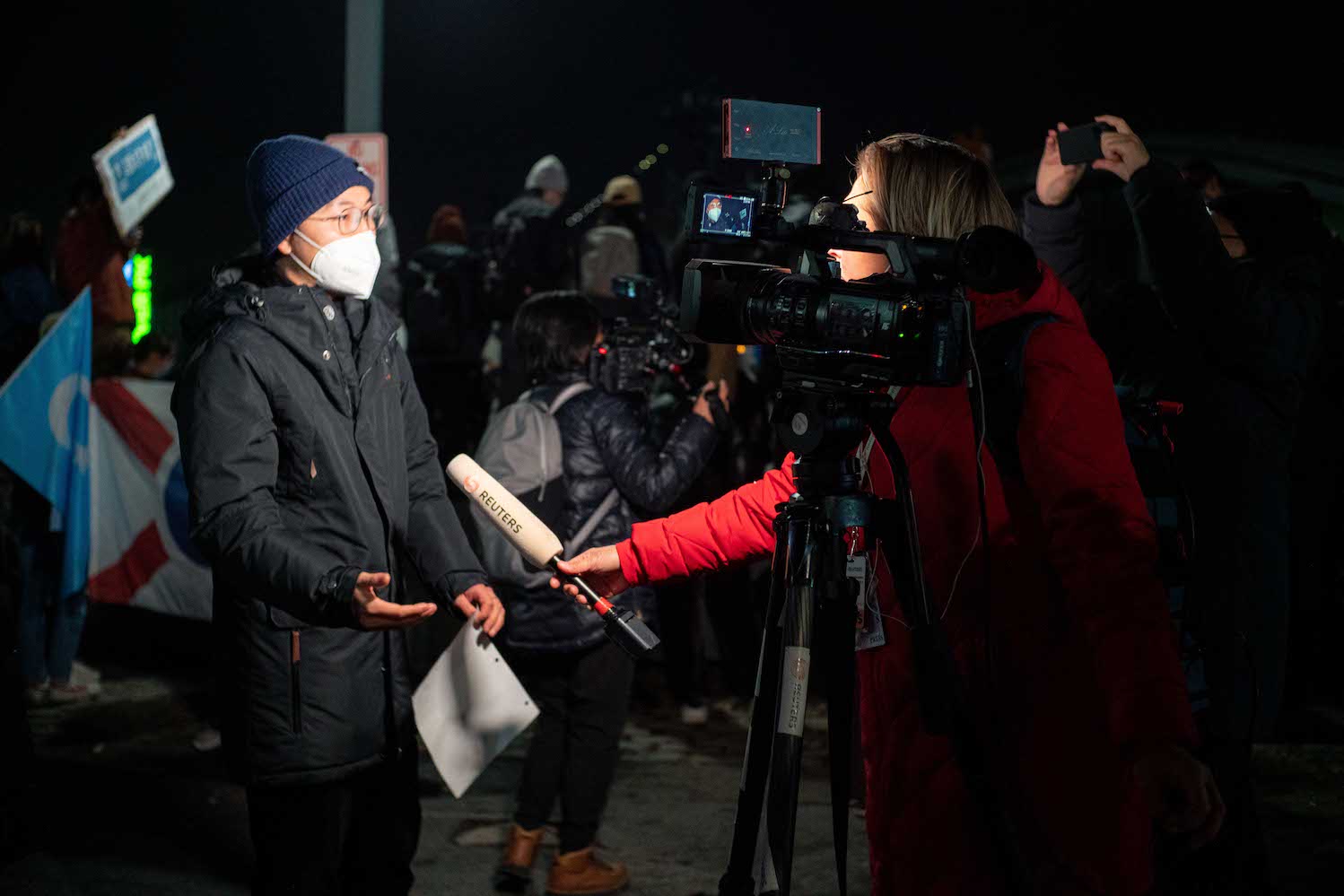 A Reuters reporter interviews a protester wearing facial masks on live television.