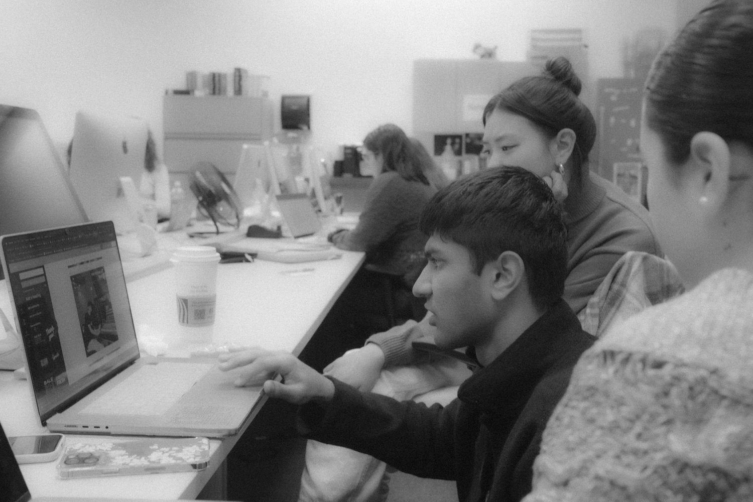 Arnav Binaykia, Eileen Liu and Camila Ceballos work on a laptop.