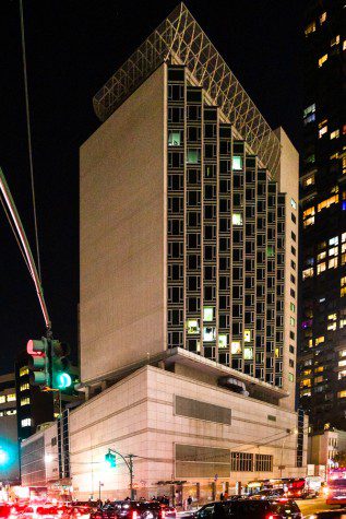 A modern building with white marble facade and diagonal windows is located at the northeast corner of 42nd Street and 12th Avenue.