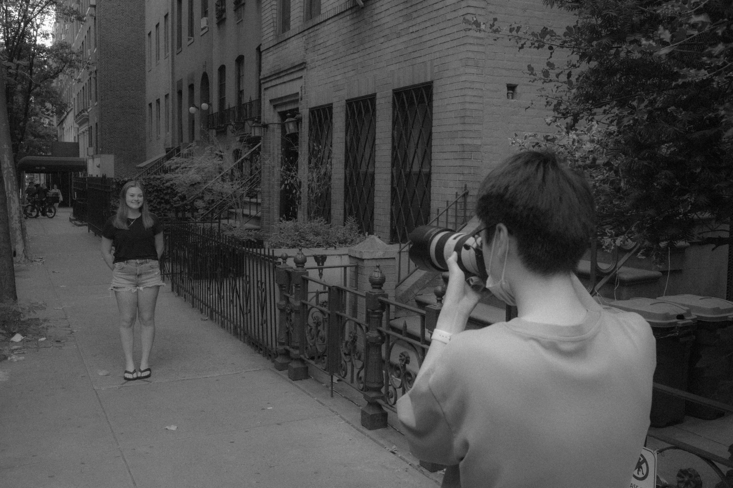 Kevin Wu photographs Natalie Thomas on the sidewalk of E. 12 St.
