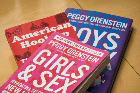 “Girls & Sex” and “Boys & Sex” by Peggy Orenstein and “American Hookup” by Lisa Wade are stacked on a wooden desk.
