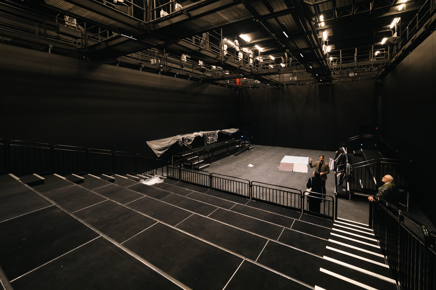 A black box theater with all black structures, floors, and grandstands.
