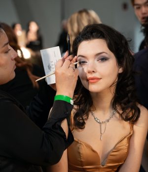 A makeup artist doing makeup for a female model.
