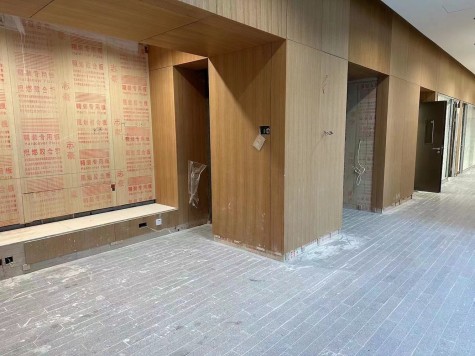 The wooden interior of a restroom entrance under construction.