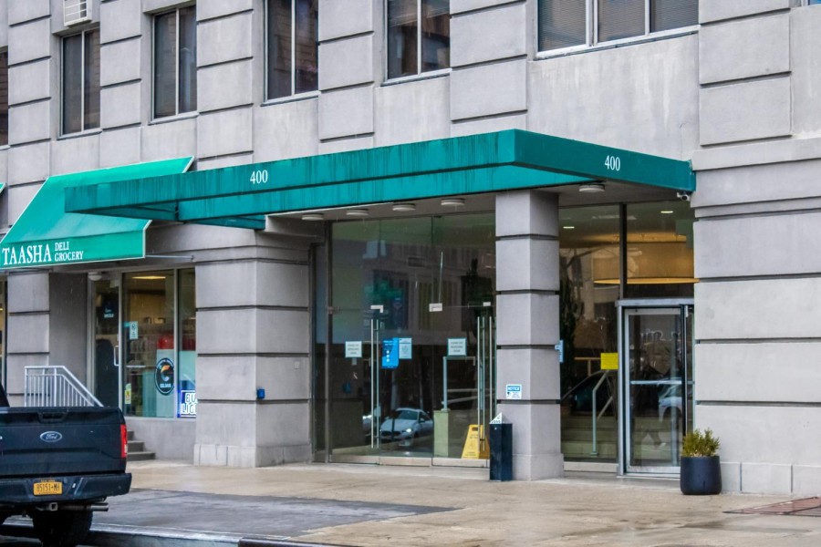 The outside of N.Y.U.s Broome Street residence hall, a beige building with a green overhang that says four-hundred.