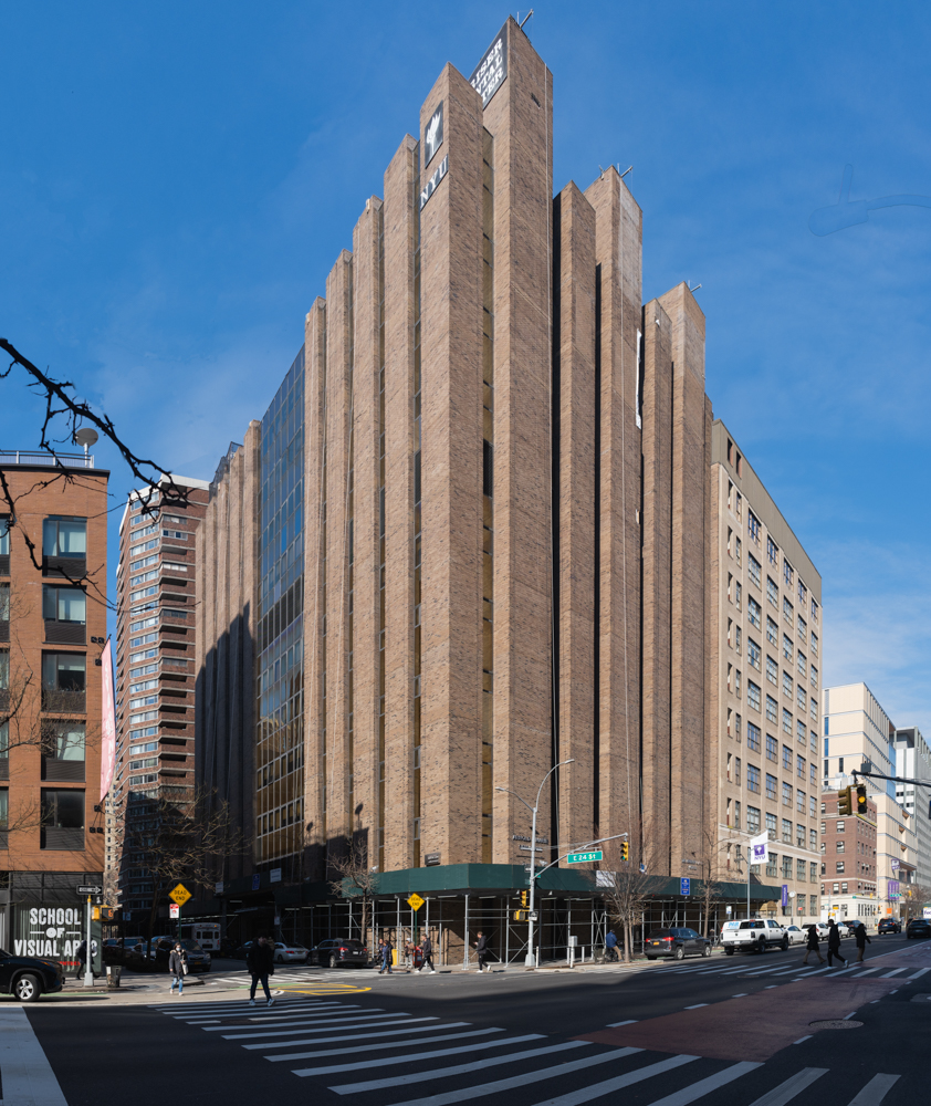 A wide angle photo of N.Y.U. College of Dentistry with a façade made of brown bricks.