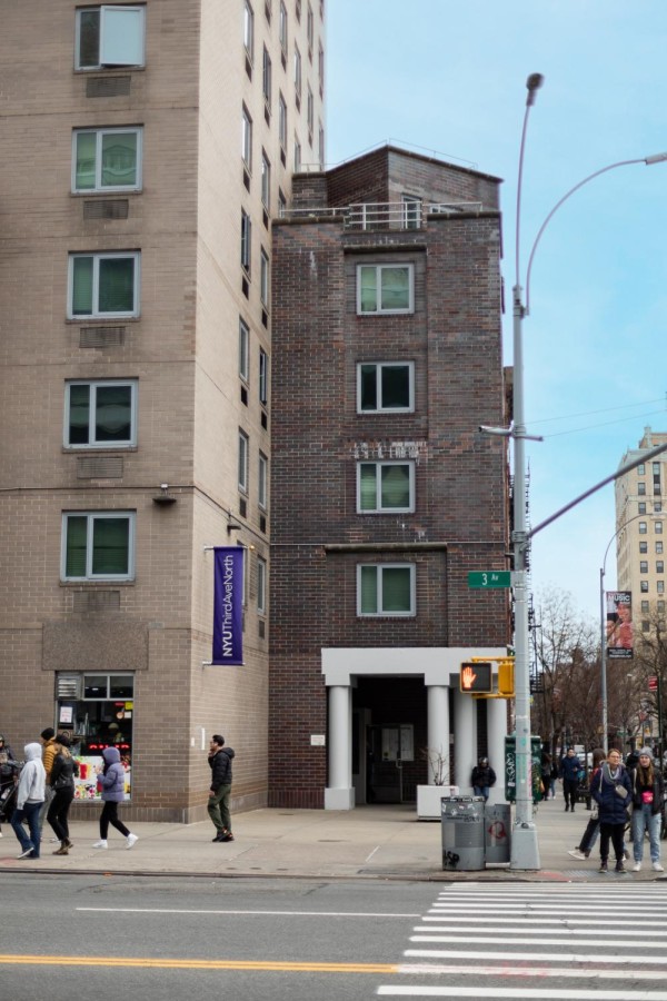 The outside of N.Y.U.s Third Avenue North residence hall as seen from across the street. People walk in front and wait at the corner of Third Avenue and Eleventh Street.