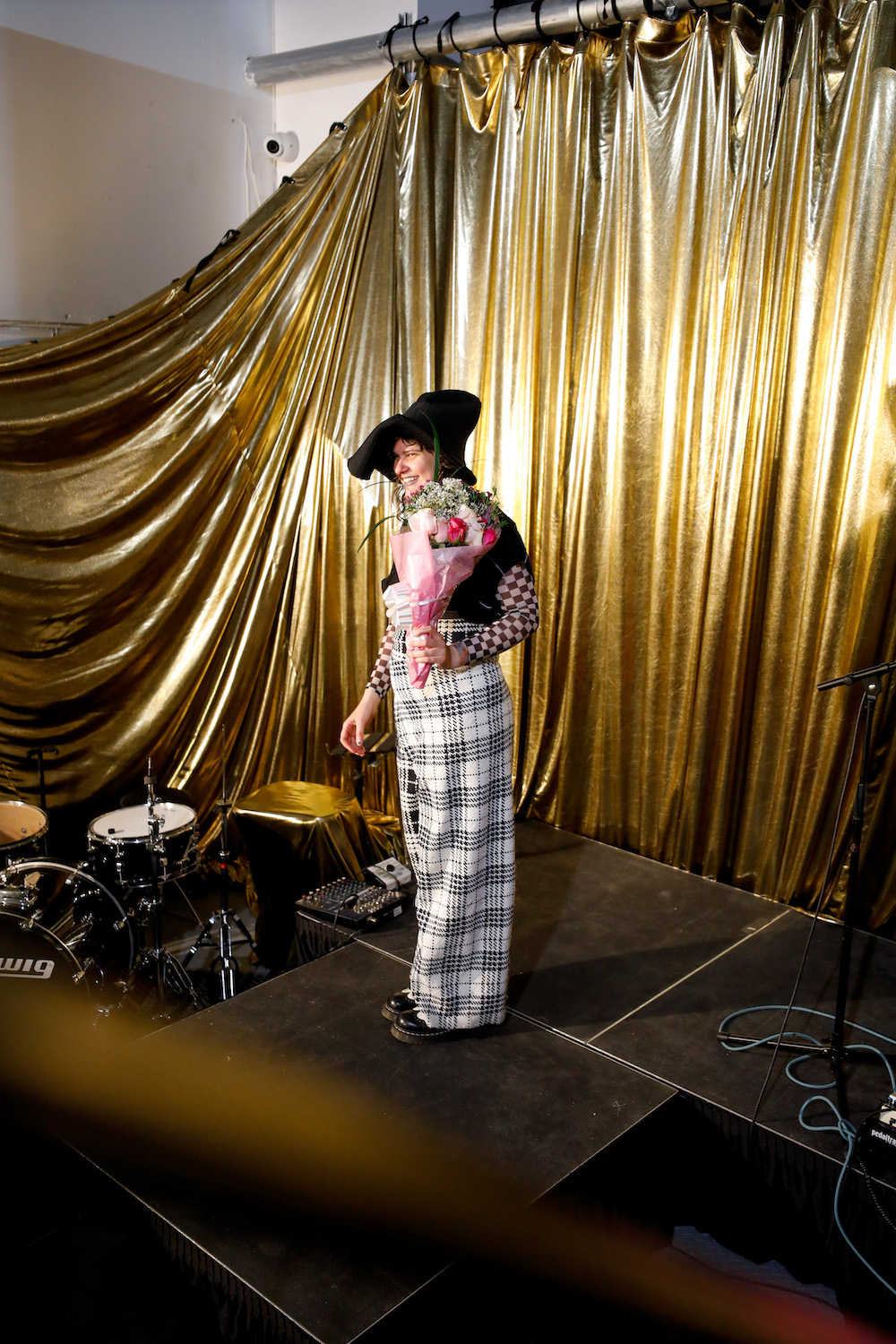 Producer of IMPACT VERS Tilly D Wolfe takes over the stage holding a bouquet of flowers after the show.