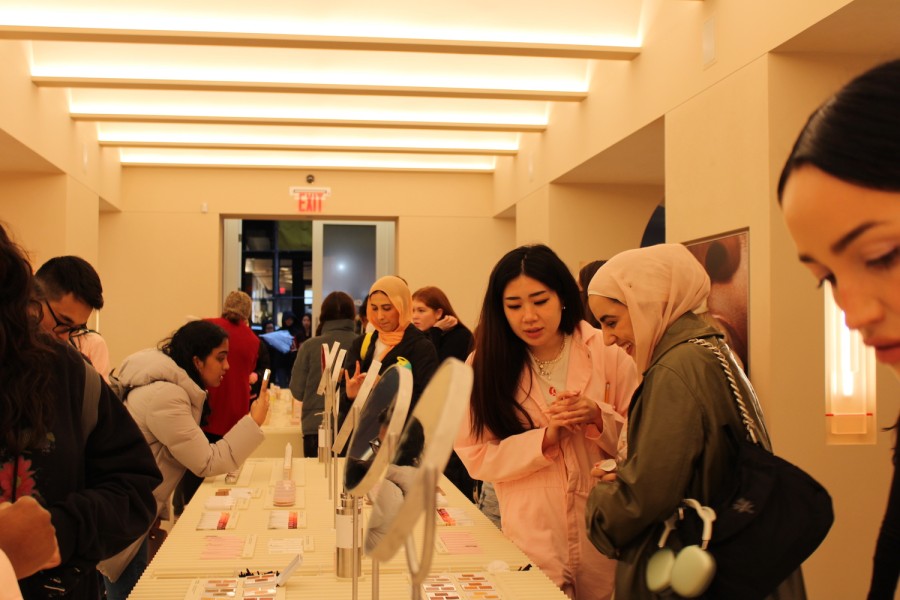 A photograph of the inside of Glossier SoHo with crowds of customers mingling and looking at products.