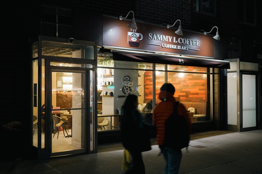 The storefront of a coffee shop at night with a sign reading “Sammy L. Coffee.”