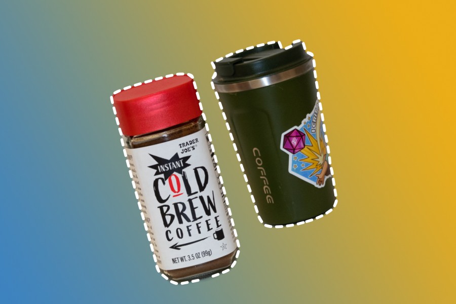 A glass jar with a red cap against a blue and yellow gradient background. On the jar is a white label with the words “Trader Joe’s Instant Cold Brew Coffee” written on it. To the left of the jar is a reusable coffee cup. The cup is green with a black top and has a multicolored sticker on the right side of it.