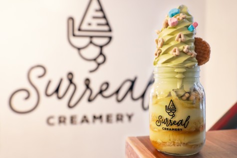 Surreal Creamery’s signature mason jar ice cream on a table. The ice cream is green and there are pieces of cereal sprinkled on it.