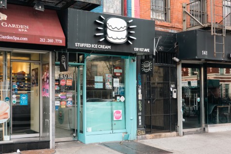 The storefront of "Stuffed Ice Cream." It is painted light blue on the outside with a black sign above, displaying a picture of the store's signature “Cruff.”