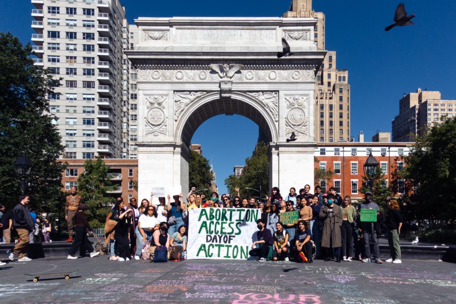 A+group+of+protesters+poses+in+front+of+the+Washington+Square+Arch+for+a+photo.+In+the+middle+is+a+banner+that+reads+%E2%80%9CAbortion+Access+Day+of+Action.%E2%80%9D