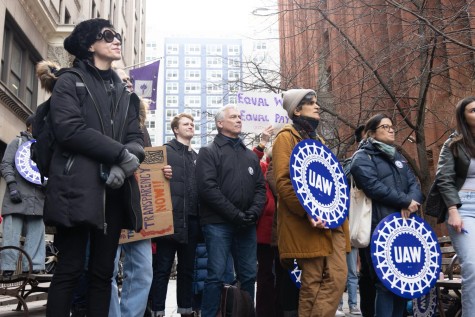 The participants of the rally stand in line with signs with the inscription "UAW" And "Equal work, equal pay"."