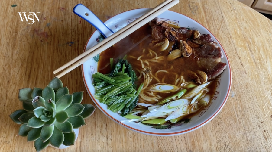 A bowl of ramen with spinach, garlic, miso and pork on top.