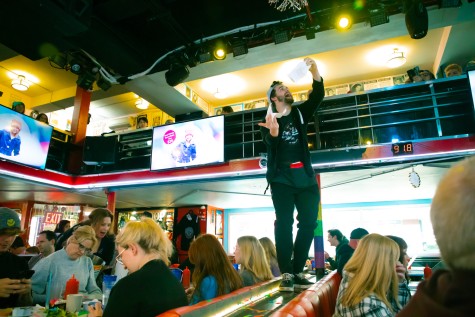 A waiter at the Stardust Diner sings and dances on top of a platform in the restaurant.