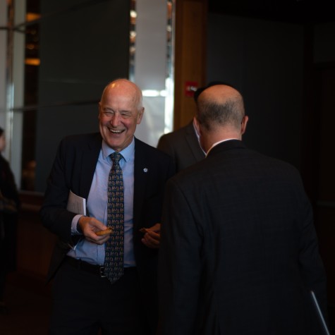 Andrew Hamilton, a man in a black suit, laughing.