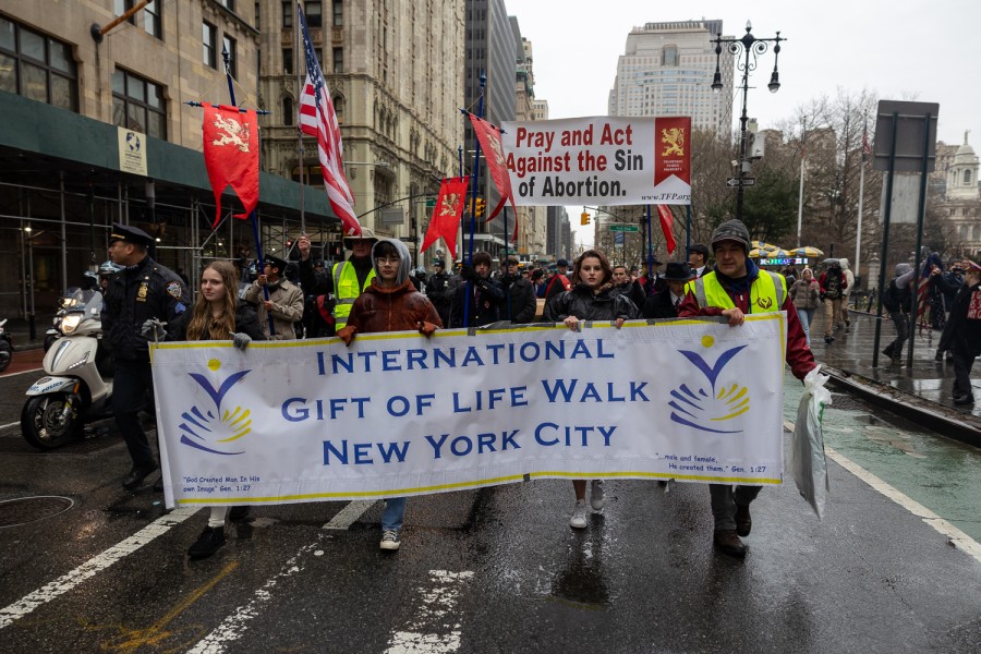 The picket line of an anti-abortion rally on Broadway. Attendees hold signs and banners that read “International Gift of Life Walk New York City” and “Pray and Act against Sin of Abortion.”