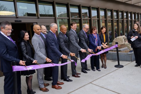 Several people in suits cutting a purple ribbon with the text “N.Y.U. Langone Health” on it. In the center is New York City Mayor Eric Adams.