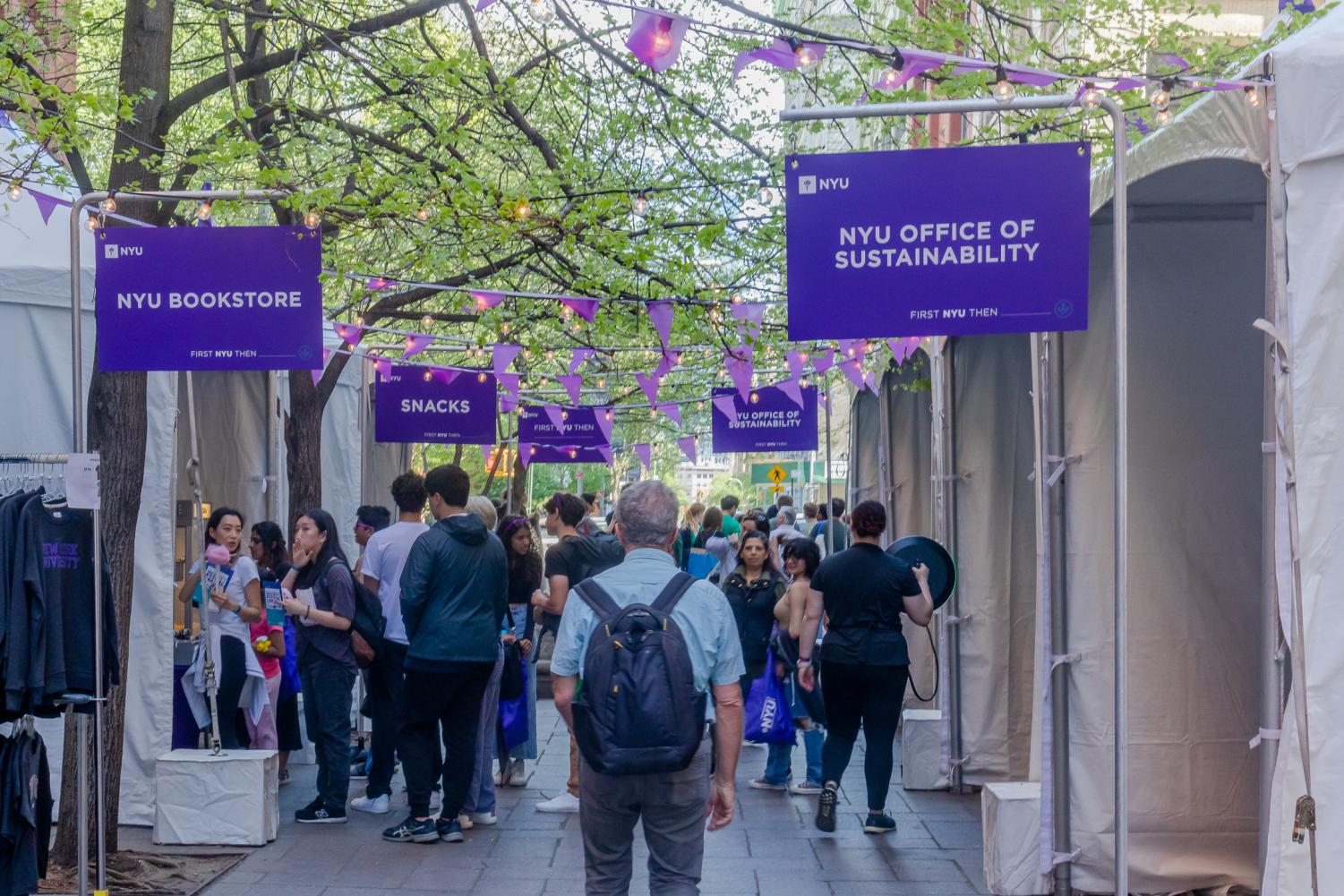 Prospective students walk through pop-up stands set up by the NYU Bookstore and Office of Sustainability.