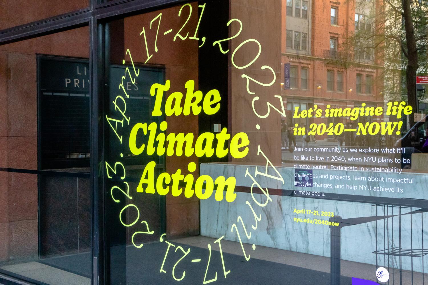 A window with a decal that reads, in bright green letters, “Take Climate Action April seventeenth through twenty-first, twenty twenty-three. Let's imagine life in twenty forty NOW! Join our community as we explore what it’ll be like to live in twenty forty, when NYU plans to be climate neutral. Participate in sustainability challenges and projects, learn about impactful lifestyle changes, and help NYU achieve its climate goals.”