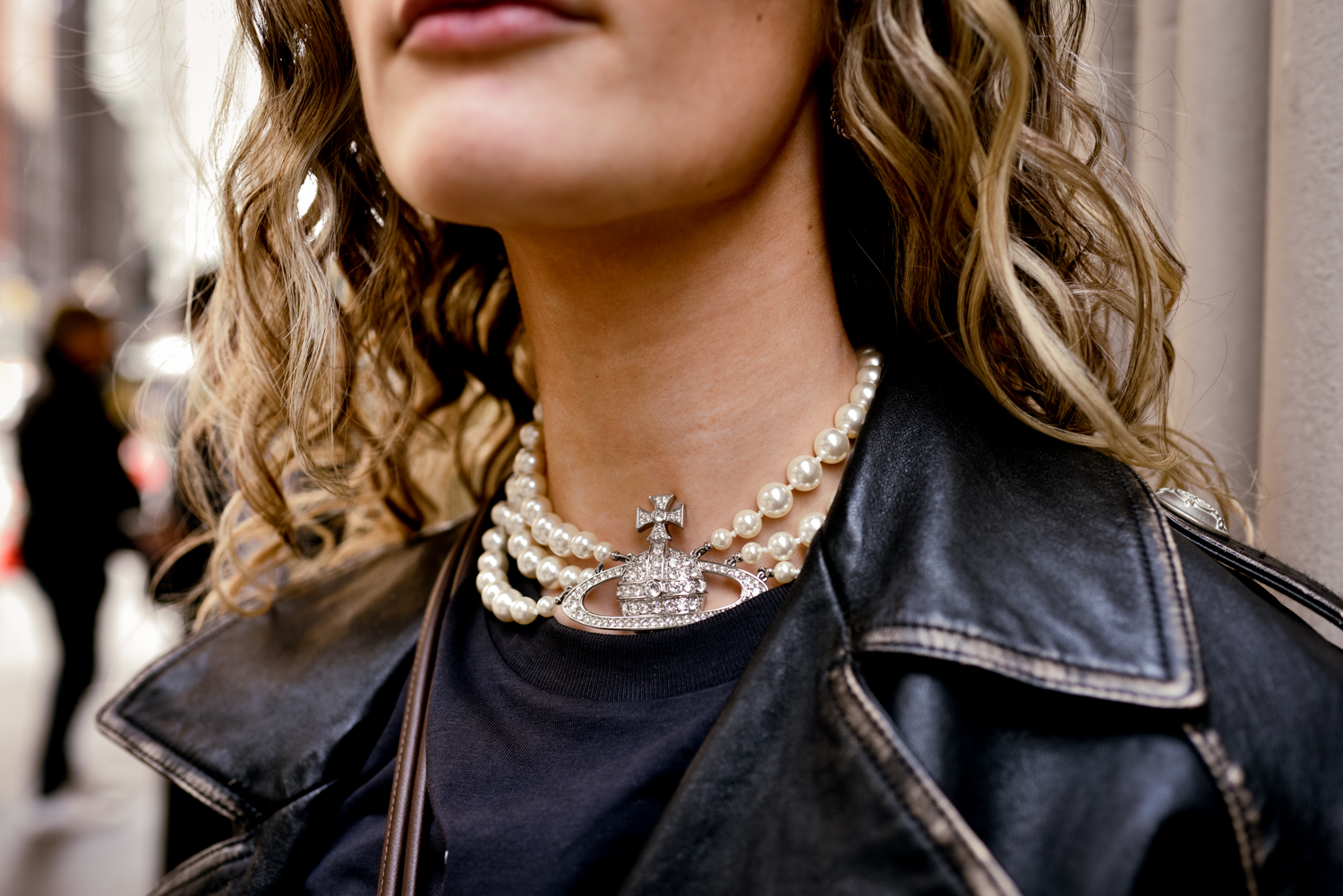 Hallie Smith stands and shows off her necklace, the Three Row Pearl Bas Relief Choker by Vivienne Westwood.