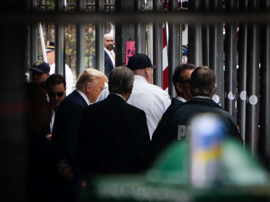 Former President Donald Trump leaving the Manhattan Criminal Court while surrounded by security guards.