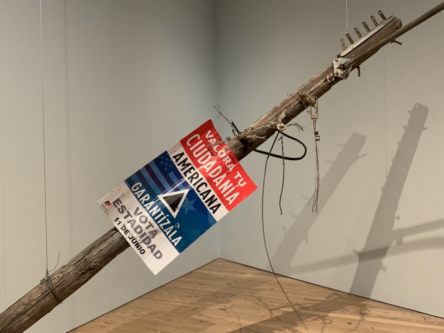 An exhibit at the Whitney Museum of American Art of a wooden electricity pole hung in the air.