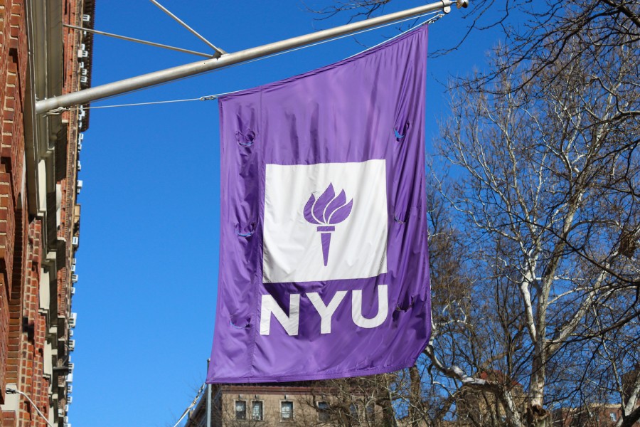 A purple flag with the logo of N.Y.U. hangs from a building.