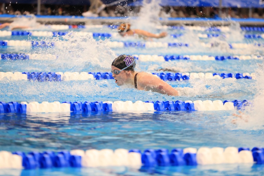 N.Y.U. swimmer Caitlin Marshall swims in a pool with other athletes in adjacent lanes.