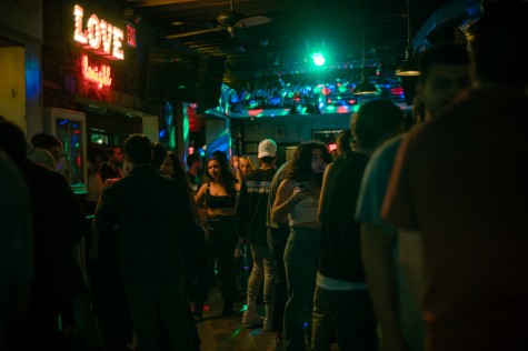 Dozens of people are engaged in conversations throughout Phebe’s. A red neon sign spelling “love tonight” emanates a soft glow.