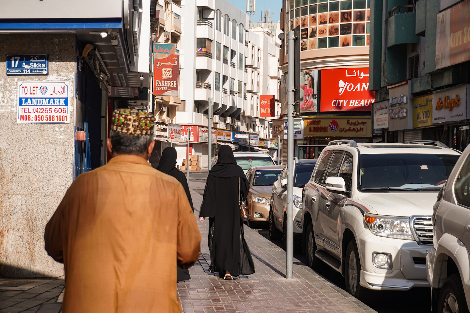 A man and two women walk on the streets of Deira, Dubai.
