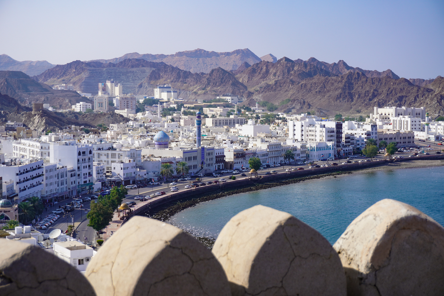 The Mutrah Corniche features white buildings and the radiant blue Mosque of the Great Prophet.