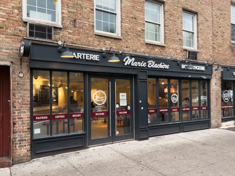 The exterior of Marie Blachère Bakery with black window frames and white signs that read “Patisserie,” “Marie Blachère” and “Boulangerie.”