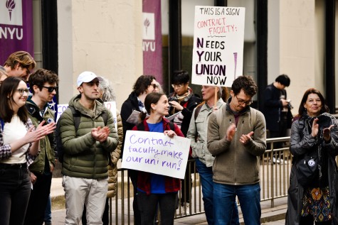 A crowd of people in Schwartz Plaza gathered for the N.Y.U. Contract Faculty Union’s May Day rally. They are holding signs and cheering.