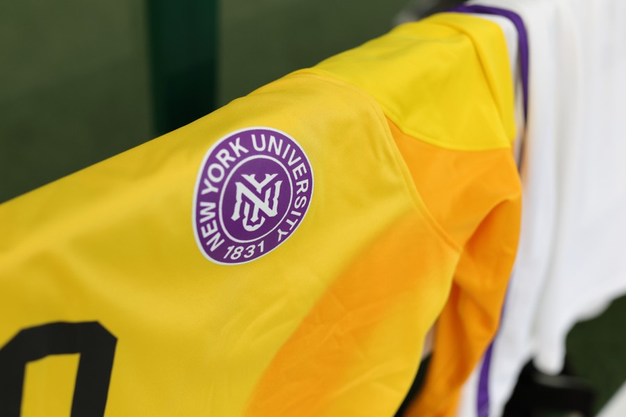 A yellow N.Y.U. Athletics jersey hangs on a pole.
