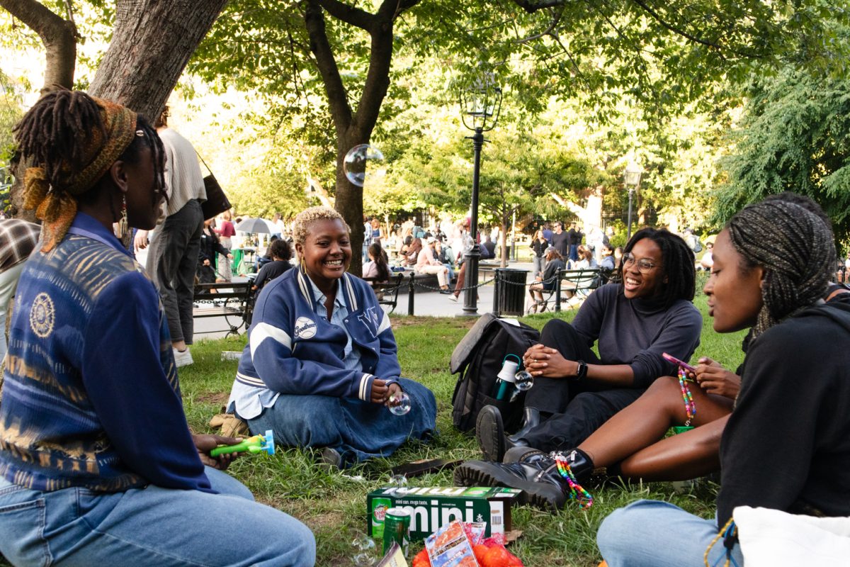 Attendees of the Brown Sugar Brilliance club meeting talking to each other in a circle while smiling. A bubble floats in the air.