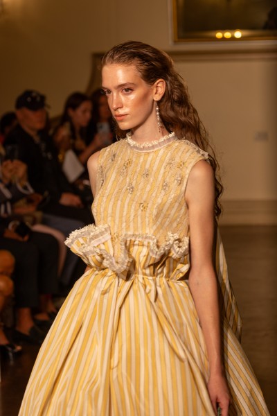 A model wears a yellow and white accented dress.