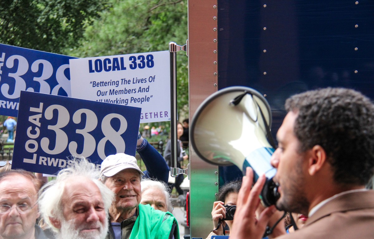 Protesters raise signs that read “Local 3.3.8. Bettering The Lives of Our Members and All Working People.”