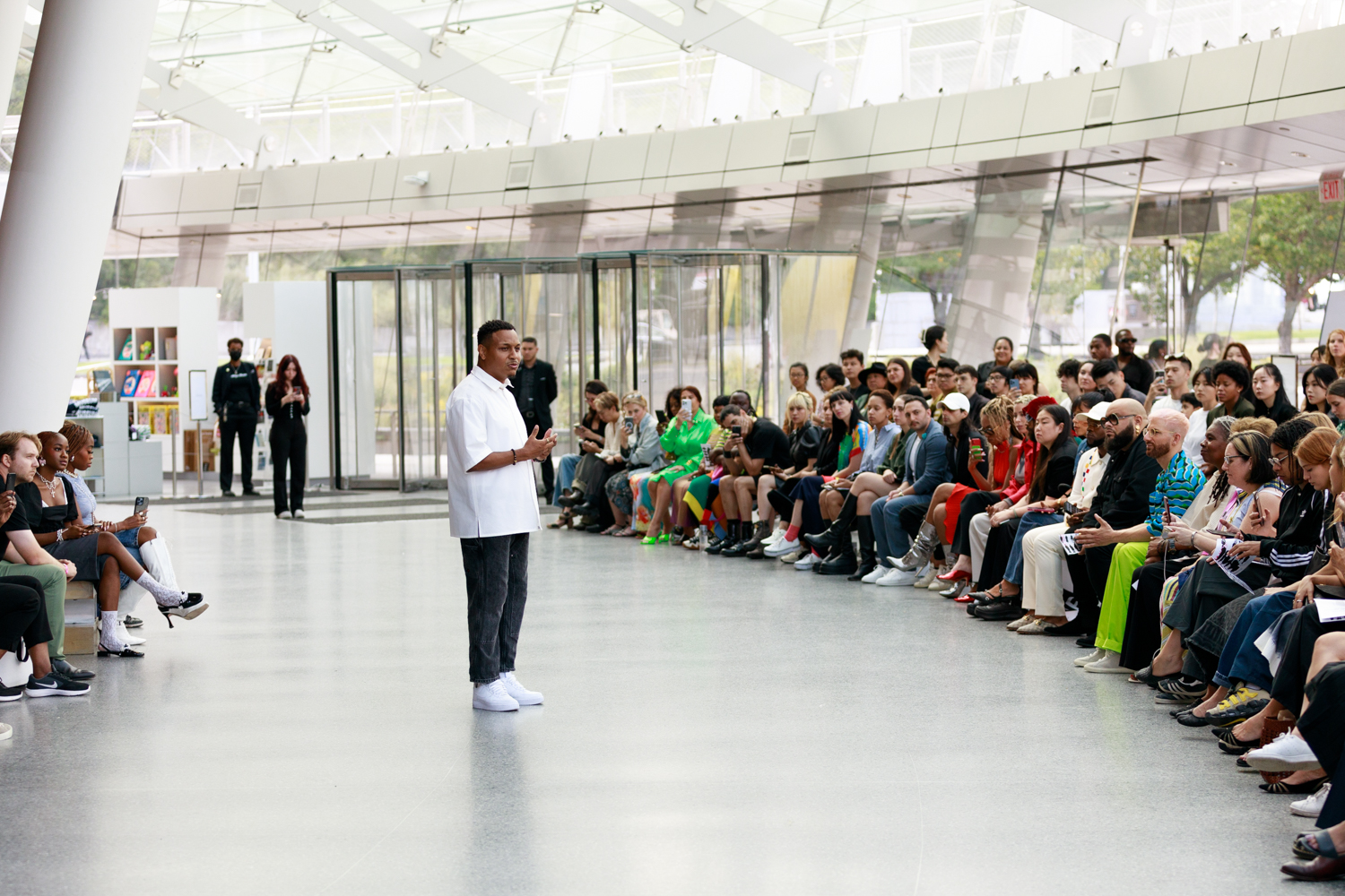 Sean Slaughter speaks to the audience wearing a white buttoned shirt and a pair of black pants.