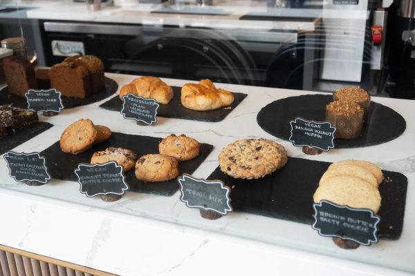Pastries such as cookies, pound cakes, and croissants displayed on the countertop of the cafe.