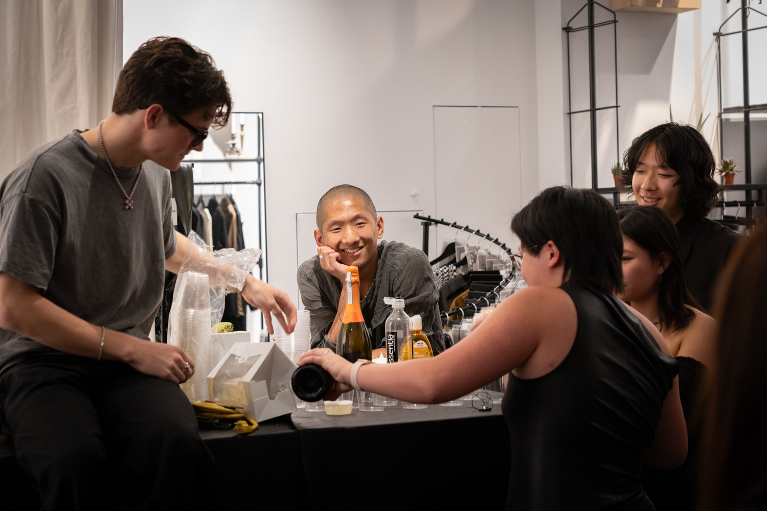 Staff members of Komune celebrating with Champagne. Martin Li is smiling in the middle.