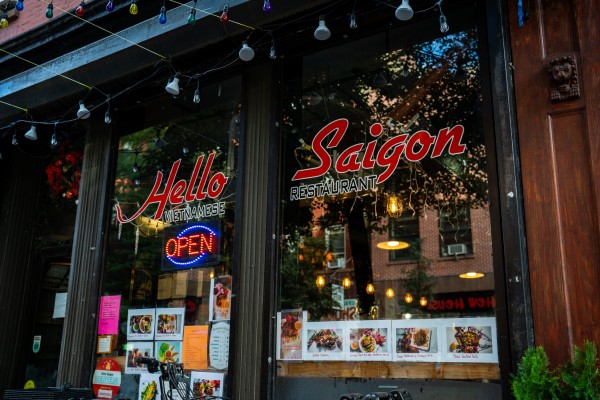 The storefront of the restaurant with the text “Hello Saigon” printed on the window.