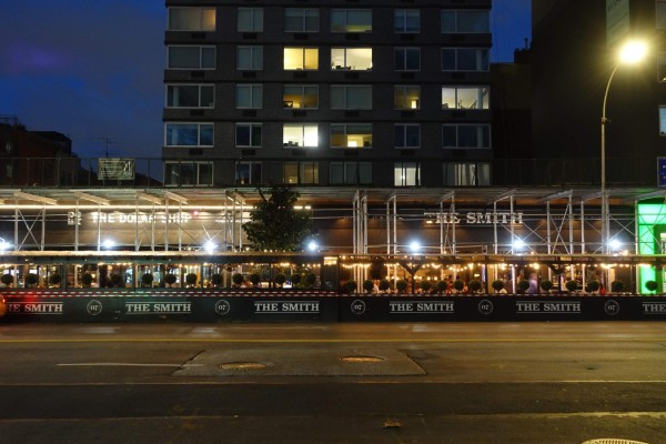 The facade of The Smith on third avenue. In front of the restaurant are outdoor dining sheds.