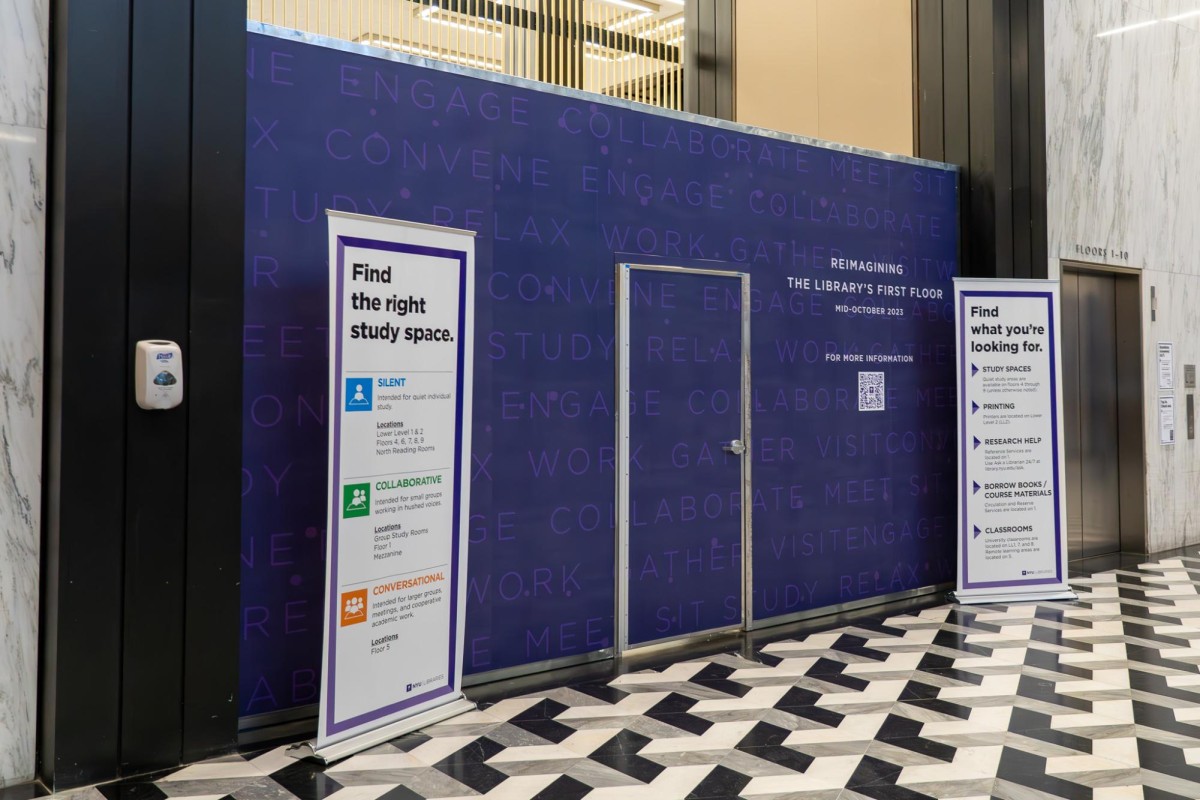 A wall covered with purple wallpaper and text saying “REIMAGINING THE LIBRARY’S FIRST FLOOR” above “MID-OCTOBER 2023.”